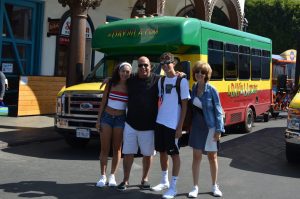 Family poses in front of the A Day in LA Tours bus. A Day in LA Tours is considered one of the best tours in Los Angeles.